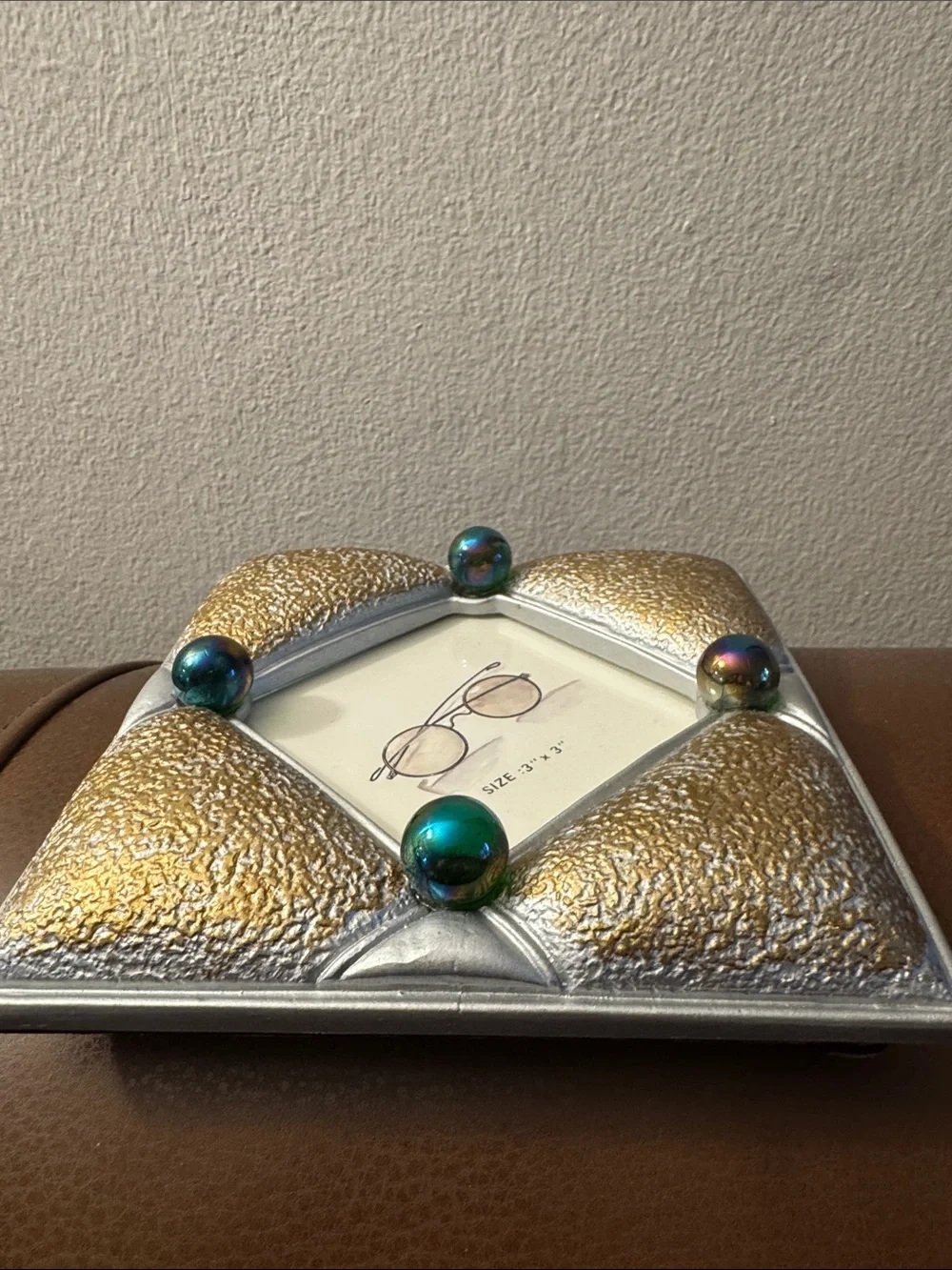 Gold and gray textured picture frame with purple iridescent marbles